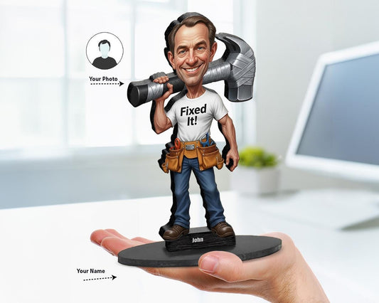 Custom caricature figurine of a smiling man in “Fixed It!” shirt holding a giant hammer and wearing a utility belt. Printed on wood or acrylic, based on customer photo.