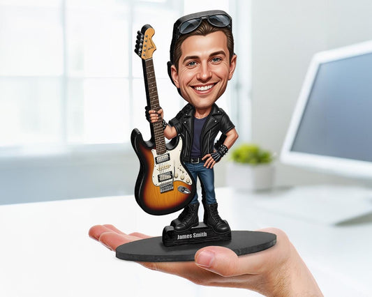 Big-head caricature of a male rock guitarist in black leather jacket holding an electric guitar, custom made from a photo, on a wood or acrylic base.